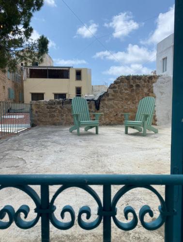 two green chairs sitting on top of a patio at Dar Alice in Soûr