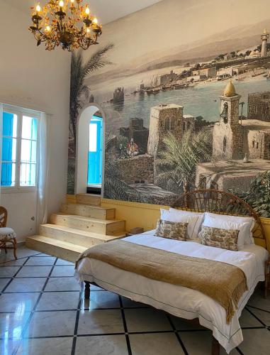a bedroom with a large painting on the wall at Dar Alice in Soûr