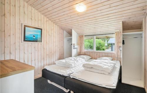 エーベルトフトにあるBeautiful Home In Ebeltoft With 5 Bedrooms, Sauna And Wifiの木製の壁にベッド2台が備わるベッドルーム1室