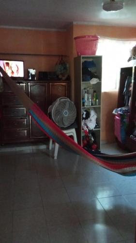 a red hammock in a room with a kitchen at Casa kansasiti in Kanasín