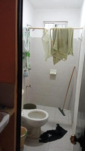 y baño con aseo, lavabo y toallas. en Casa kansasiti, en Kanasín