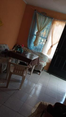 a living room with a table and a window at Casa kansasiti in Kanasín