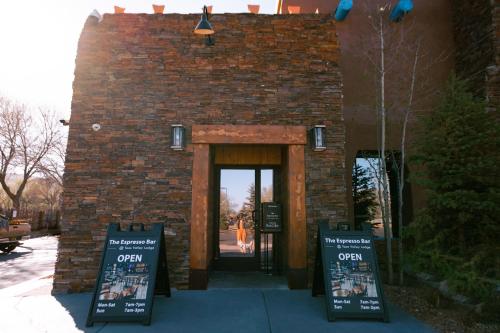 a brick building with an open door with signs in front at Taos Valley Lodge in Taos