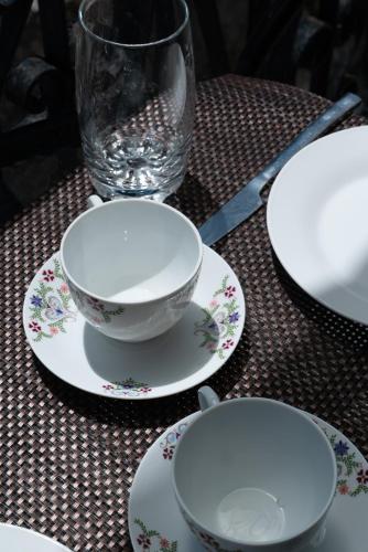 a table with three plates and a glass on it at Tsartsada house in Áno Lefkímmi