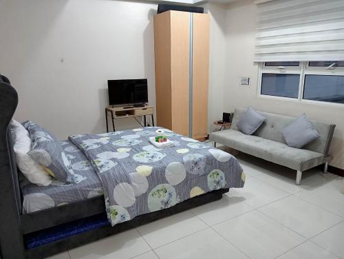 een slaapkamer met een bed en een bank bij 101 condo furnished walking distance NIAA 3 in Manilla