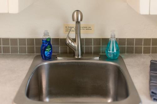 a kitchen sink with two bottles of detergent on it at Oakdale Suites - Master Property in Medford