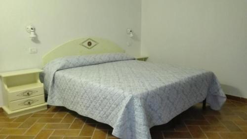 a bedroom with a bed and a night stand at Mandorlo 2 in Santa Maria Navarrese