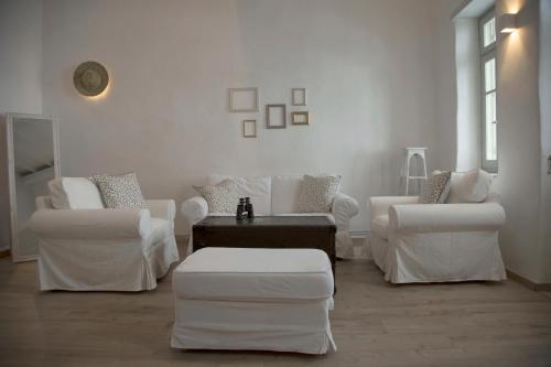 a white living room with white chairs and a table at Traditional Village House in Istérnia