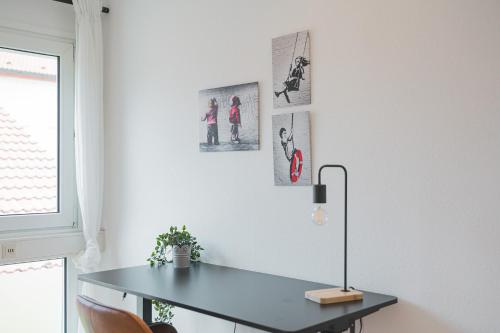 escritorio en una habitación con mesa y ventana en Lemon Suites Hildrizhausen - Ideal für Teams und Monteure, en Hildrizhausen