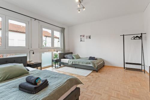 1 dormitorio con cama, sofá y ventanas en Lemon Suites Hildrizhausen - Ideal für Teams und Monteure, en Hildrizhausen