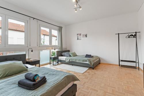 a bedroom with a bed and a couch and windows at Lemon Suites Hildrizhausen - Ideal für Teams und Monteure in Hildrizhausen
