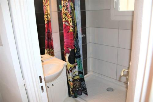 une salle de bain avec toilettes et rideau de douche dans l'établissement Villa 24, Port Vénus au village naturiste, au Cap d'Agde