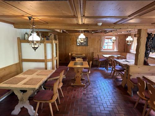 a restaurant with wooden tables and chairs in a room at Hotel Tschuggen Davos in Davos