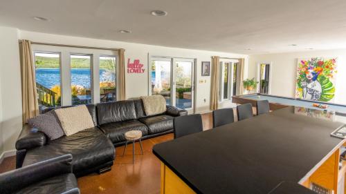 a living room with a couch and a ping pong table at Lakefront, Dock, Hottub, Pooltable, Kayaks, 75"tv in Lake Ariel