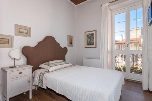 um quarto com uma cama grande e uma janela em Borgo Prima Luce em Cuglieri