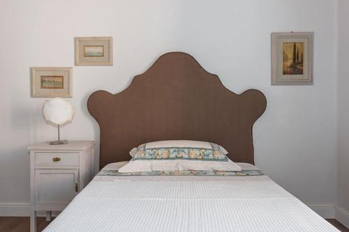 a bed with a wooden headboard in a bedroom at Borgo Prima Luce in Cuglieri