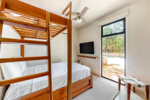1 dormitorio con literas, TV y ventana en TAO Edena 30, en Tulum
