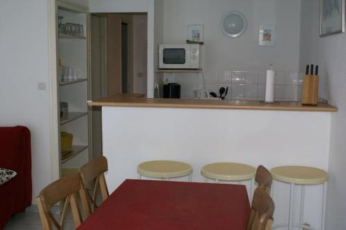 een keuken met een tafel en een aanrecht met een magnetron bij Appart 801, Tennis village in Cap d'Agde