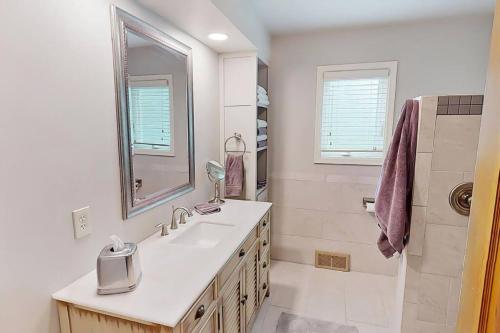 La salle de bains blanche est pourvue d'un lavabo et d'une douche. dans l'établissement Lakeside Home, à Sauk Centre
