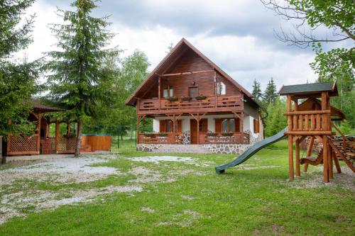 a house with a slide in front of it at Kamilla Vendégház Borzont in Borzont