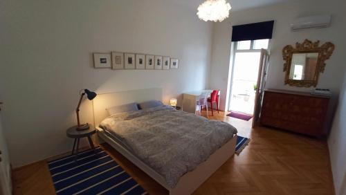 a bedroom with a bed and a lamp and a mirror at Apartment LAUREL Center Opatija in Opatija