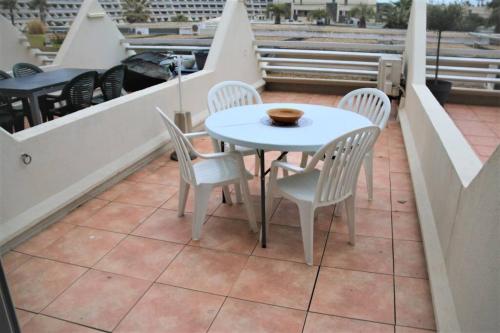 une table blanche et des chaises sur un balcon dans l'établissement Studio 19, Héliopolis FGH au Village naturiste, au Cap d'Agde