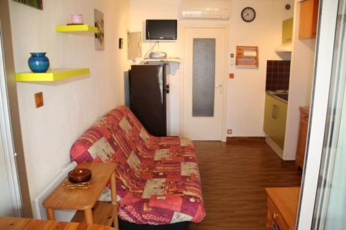 - un salon avec un canapé et un réfrigérateur dans l'établissement Studio 19, Héliopolis FGH au Village naturiste, au Cap d'Agde