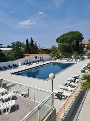 una piscina con tumbonas y un complejo en Joli Mobil Home, en Agde