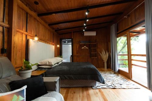 a bedroom with a bed and a couch at Cabana Grafe in Bento Gonçalves