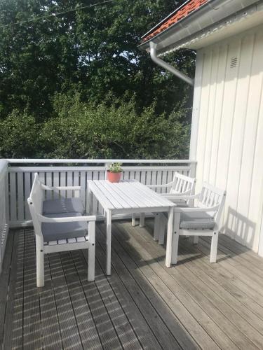 a picnic table and two chairs on a deck at Rum på hästgård in Holmsjö