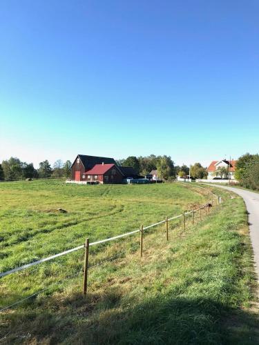 a fence in a field next to a road at Rum på hästgård in Holmsjö