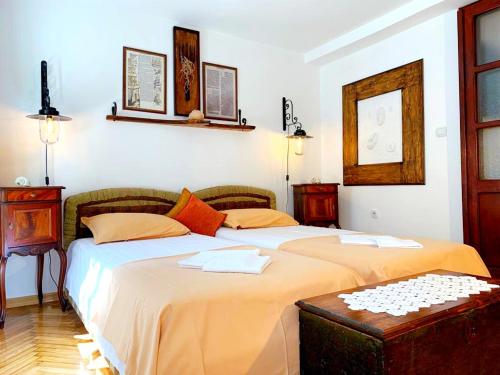 two twin beds in a room with two tables at Villa Urbana, Old Town Budva in Budva
