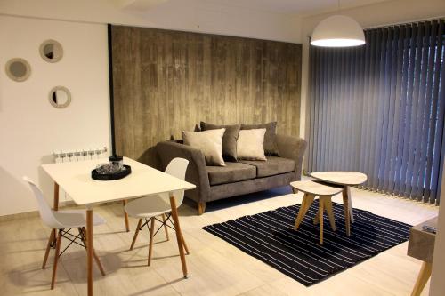 uma sala de estar com um sofá, uma mesa e cadeiras em Mendoza Relax and Comfort II em Mendoza