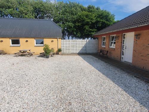 a backyard with a picnic table and a building at Stort værelse med tekøkken, tæt på hav og fjord. in Bedsted Thy