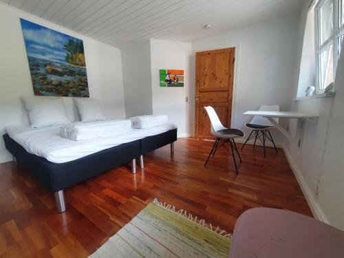 ein Schlafzimmer mit einem Bett, einem Tisch und einem Stuhl in der Unterkunft Stort værelse med tekøkken, tæt på hav og fjord. in Bedsted Thy