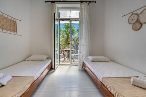 two beds in a room with a balcony at Tsartsada house in Áno Lefkímmi