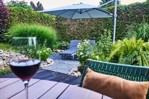 a glass of wine sitting on a table with an umbrella at PRIMERA am See in Gaienhofen