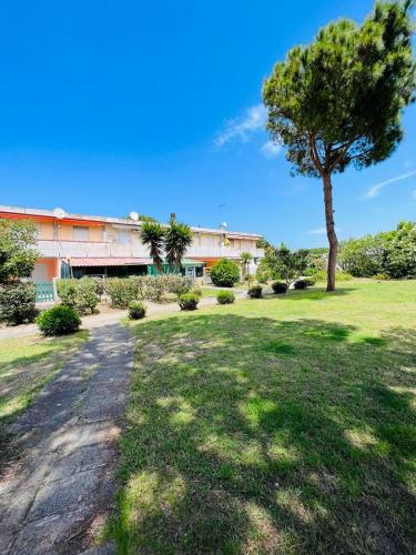 a park with a tree and a building at Silvy's Sunny House in Platamona