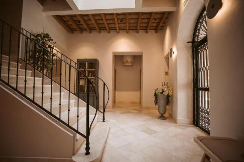 a hallway with stairs and a vase of flowers at Casa Aura Hotel in Vejer de la Frontera