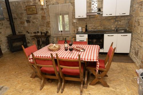 a kitchen with a table with a red and white table cloth at Apartment Rural Podastrana in Sinj