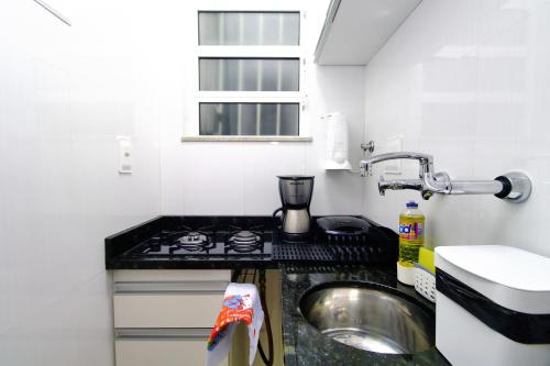 uma pequena cozinha com um lavatório e um fogão em Rio Spot Homes Copacabana U041 no Rio de Janeiro