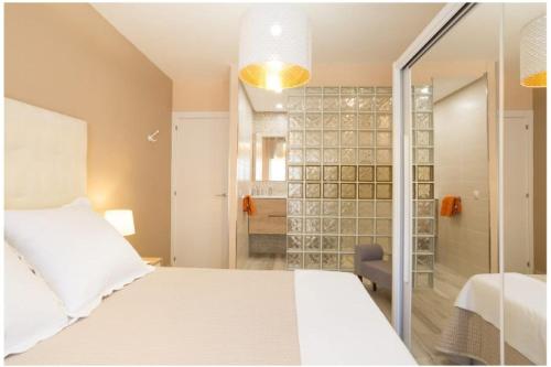 1 dormitorio con cama blanca y ducha en Torremolinos Bajondillo beach, en Torremolinos