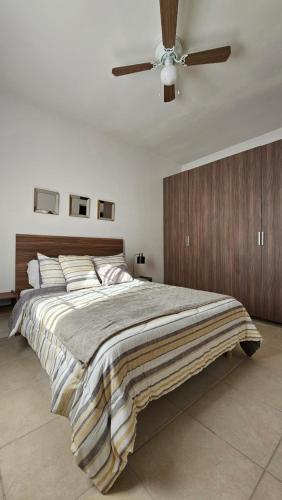 a bedroom with a large bed with a ceiling fan at Departamento Frontera #3 en el Campestre in Ciudad Juárez