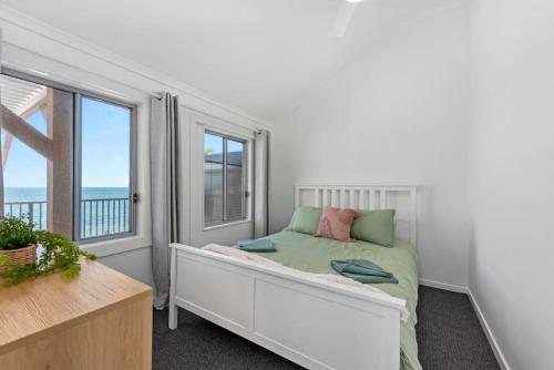 a bedroom with a bed and a large window at Bay Vista Two Bedroom Waterfront Apartment in Redcliffe