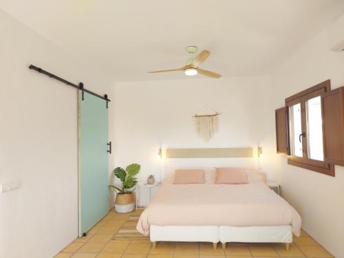 a bedroom with a white bed and a ceiling fan at Casa A.Mar in Las Negras
