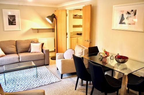 ein Wohnzimmer mit einem Tisch und einem Sofa in der Unterkunft Mathus Gardens in Cambridge