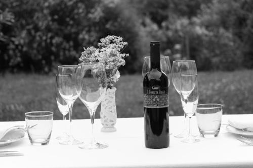 a bottle of wine sitting on a table with wine glasses at Agriturismo Gaggioli Borgo Delle Vigne in Zola Predosa