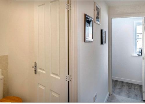 a bathroom with a white door and a toilet at Affordable single room 