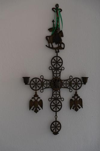 a cross hanging on a wall with a lizard on it at Tsartsada house in Áno Lefkímmi