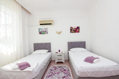 two beds in a room with white walls at Deep Purple Bikers in Fethiye